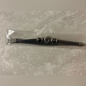 Leather style black bracelet with silver details.